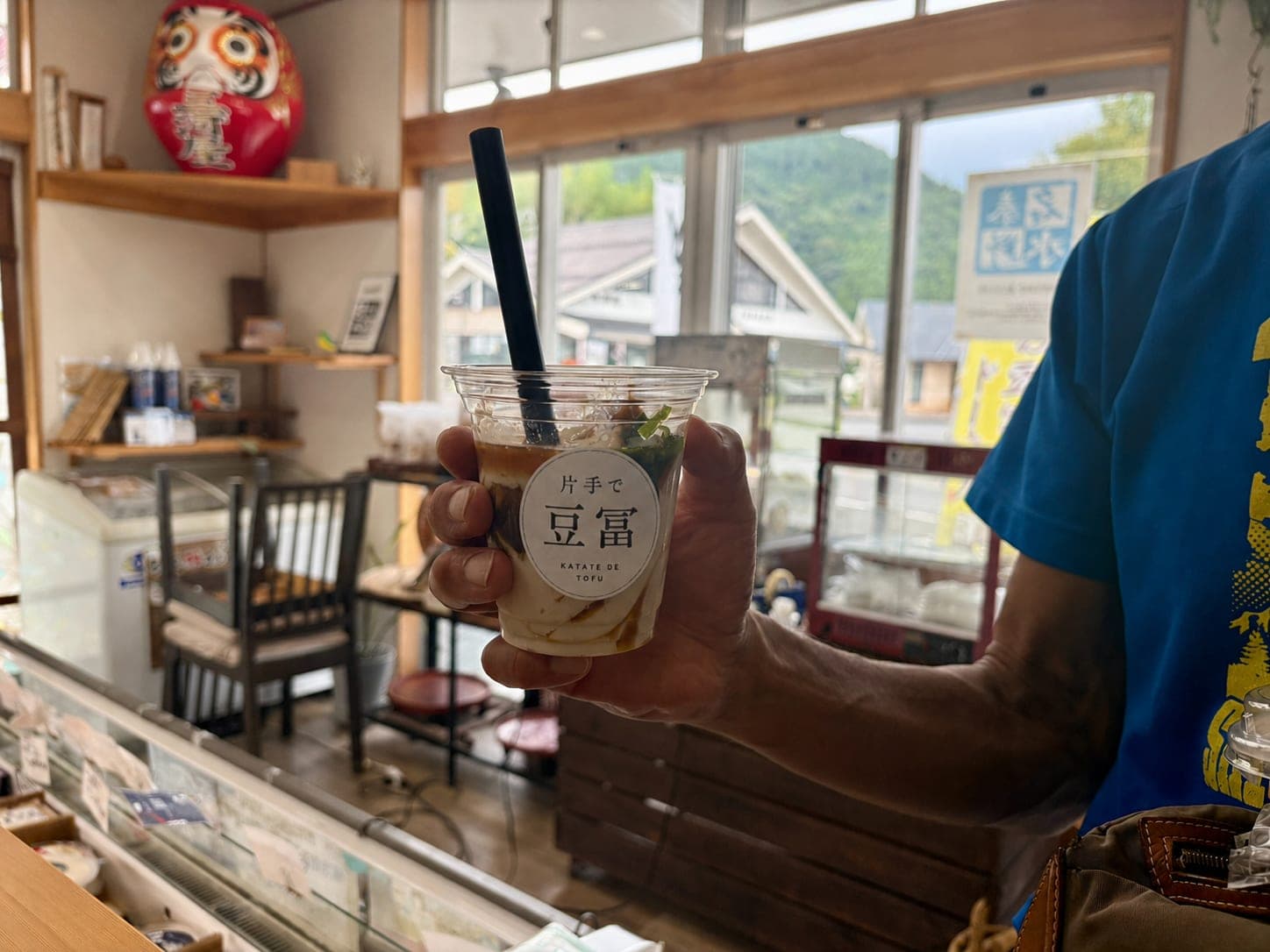 山守茶屋の店内で片手で豆冨を持つ様子
